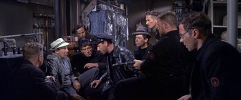 Movie still from “The Russians Are Coming the Russians Are Coming” (1966), directed by Norman Jewison – A group of men sitting next to each other in a room; Medium shot, High angle