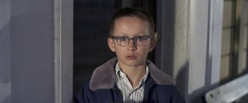 Movie still from “The Russians Are Coming the Russians Are Coming” (1966), directed by Norman Jewison – A young boy wearing glasses and a blue jacket; Close Up shot, Low angle