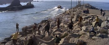Movie still from “The Russians Are Coming the Russians Are Coming” (1966), directed by Norman Jewison – A group of people walking along a rocky shore; Extreme Wide shot, High angle