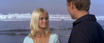 Movie still from “The Russians Are Coming the Russians Are Coming” (1966), directed by Norman Jewison – A man and a woman standing next to each other on the beach; Close Up shot, Over the shoulder angle