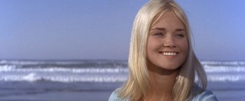 Movie still from “The Russians Are Coming the Russians Are Coming” (1966), directed by Norman Jewison – A beautiful blond haired woman standing in front of the ocean; Close Up shot, Low angle