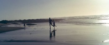 Movie still from “The Russians Are Coming the Russians Are Coming” (1966), directed by Norman Jewison – A man and a dog playing on the beach; Extreme Wide shot, High angle