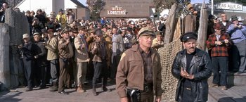 Movie still from “The Russians Are Coming the Russians Are Coming” (1966), directed by Norman Jewison – A crowd of people standing in front of a building; Wide shot, Over the shoulder angle