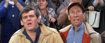 Movie still from “The Russians Are Coming the Russians Are Coming” (1966), directed by Norman Jewison – Two men and an old man in a crowd of people; Close Up shot, Low angle