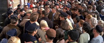Movie still from “The Russians Are Coming the Russians Are Coming” (1966), directed by Norman Jewison – A group of people standing around each other in front of a crowd; Medium shot, High angle
