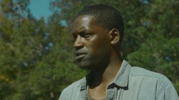 Movie still from “The Sacrament” (2013), directed by Ti West – A person wearing a gray shirt; Close Up shot, Low angle