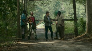Movie still from “The Sacrament” (2013), directed by Ti West – A group of men standing on the side of a road; Wide shot, Over the shoulder angle
