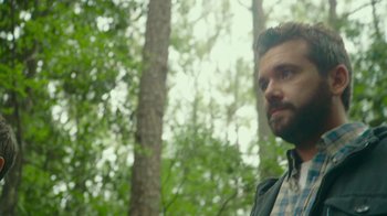 Movie still from “The Sacrament” (2013), directed by Ti West – A man standing next to a tree in the woods; Close Up shot, Over the shoulder angle