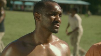 Movie still from “The Sacrament” (2013), directed by Ti West – A person with no shirt in a field; Close Up shot, Low angle