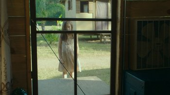 Movie still from “The Sacrament” (2013), directed by Ti West – A little girl standing in front of an open window; Wide shot, High angle