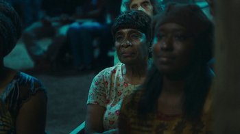 Movie still from “The Sacrament” (2013), directed by Ti West – A group of people sitting next to each other in a room; Close Up shot, Over the shoulder angle