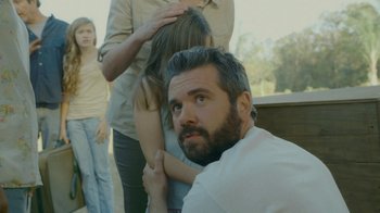 Movie still from “The Sacrament” (2013), directed by Ti West – A man with a goatee and a beard is looking at a woman; Close Up shot, Over the shoulder angle