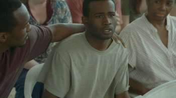 Movie still from “The Sacrament” (2013), directed by Ti West – A man with his hand on the shoulder of another man; Close Up shot, Over the shoulder angle