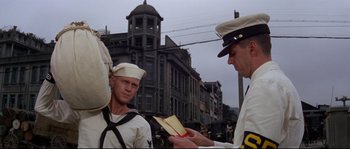 Movie still from “The Sand Pebbles” (1966), directed by Robert Wise – Two men in uniform are exchanging a letter; Medium shot, Low angle