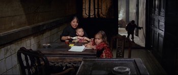 Movie still from “The Sand Pebbles” (1966), directed by Robert Wise – A woman and two children sitting at a table; Medium shot, High angle