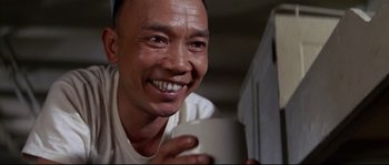 Movie still from “The Sand Pebbles” (1966), directed by Robert Wise – A man holding a coffee cup and smiling; Close Up shot, Low angle