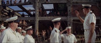 Movie still from “The Sand Pebbles” (1966), directed by Robert Wise – A group of men standing next to each other in a building; Extreme Wide shot, Low angle