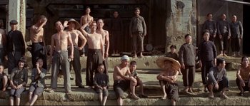 Movie still from “The Sand Pebbles” (1966), directed by Robert Wise – A group of people sitting on some steps; Wide shot, Low angle