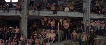 Movie still from “The Sand Pebbles” (1966), directed by Robert Wise – A group of men sitting on top of a wooden structure; Wide shot, High angle