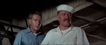 Movie still from “The Sand Pebbles” (1966), directed by Robert Wise – A man in a white shirt and a man in a blue shirt; Close Up shot, Low angle