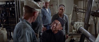 Movie still from “The Sand Pebbles” (1966), directed by Robert Wise – A group of men standing next to each other in a room; Medium shot, Over the shoulder angle