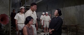 Movie still from “The Sand Pebbles” (1966), directed by Robert Wise – A group of men and women standing next to each other; Medium shot, Over the shoulder angle