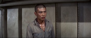 Movie still from “The Sand Pebbles” (1966), directed by Robert Wise – A man with a shaved head is standing in front of a wall; Close Up shot, High angle