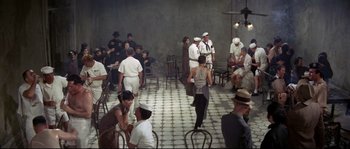 Movie still from “The Sand Pebbles” (1966), directed by Robert Wise – A group of people sitting around a room; Wide shot, High angle