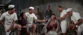 Movie still from “The Sand Pebbles” (1966), directed by Robert Wise – A group of people standing in a room with boxing gloves on; Medium shot, High angle