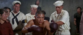 Movie still from “The Sand Pebbles” (1966), directed by Robert Wise – A group of men standing next to each other with boxing mitts on; Medium shot, Low angle