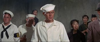 Movie still from “The Sand Pebbles” (1966), directed by Robert Wise – A man wearing a white hat in a room; Medium shot, Low angle