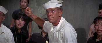 Movie still from “The Sand Pebbles” (1966), directed by Robert Wise – A man wearing a white hat and a white shirt; Close Up shot, Low angle