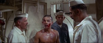 Movie still from “The Sand Pebbles” (1966), directed by Robert Wise – A man with blood all over his face; Medium shot, Over the shoulder angle