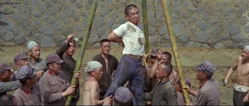 Movie still from “The Sand Pebbles” (1966), directed by Robert Wise – A group of men standing next to each other on a swing; Wide shot, Low angle