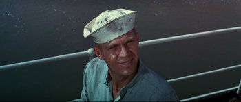 Movie still from “The Sand Pebbles” (1966), directed by Robert Wise – A man wearing a white hat on top of a boat; Close Up shot, Low angle