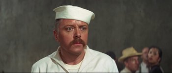 Movie still from “The Sand Pebbles” (1966), directed by Robert Wise – A person with a mustache wearing a hat; Close Up shot, High angle