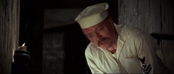 Movie still from “The Sand Pebbles” (1966), directed by Robert Wise – A man with a beard wearing a white hat; Close Up shot, Low angle
