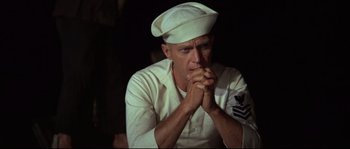 Movie still from “The Sand Pebbles” (1966), directed by Robert Wise – A man in a sailor's uniform is praying; Close Up shot, Low angle