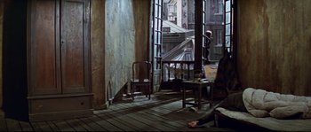 Movie still from “The Sand Pebbles” (1966), directed by Robert Wise – A person laying on the ground in a room; Wide shot, High angle