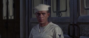 Movie still from “The Sand Pebbles” (1966), directed by Robert Wise – A man wearing a white hat and a white uniform; Close Up shot, Over the shoulder angle