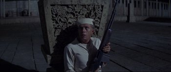 Movie still from “The Sand Pebbles” (1966), directed by Robert Wise – A man holding a rifle while wearing a sailor's hat; Medium shot, High angle