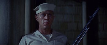 Movie still from “The Sand Pebbles” (1966), directed by Robert Wise – A man wearing a sailor's hat and holding a rifle; Close Up shot, Low angle