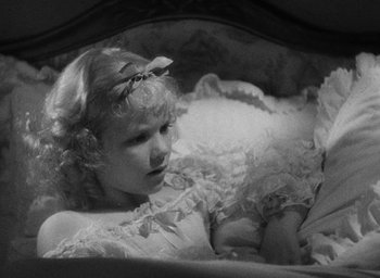 Movie still from “The Scarlet Empress” (1934), directed by Josef von Sternberg – A young girl in a white dress is laying in a bed; Close Up shot, High angle