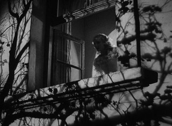 Movie still from “The Scarlet Empress” (1934), directed by Josef von Sternberg – A black and white photo of a woman looking out of a window; Wide shot, Low angle