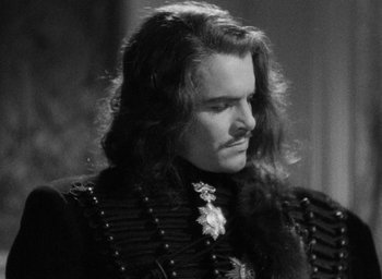 Movie still from “The Scarlet Empress” (1934), directed by Josef von Sternberg – A black and white photo of a man with long hair; Close Up shot, Over the shoulder angle
