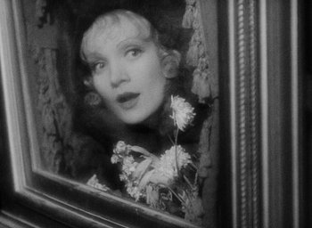 Movie still from “The Scarlet Empress” (1934), directed by Josef von Sternberg – A black - and - white photo of a woman looking out of a window; Close Up shot, Over the shoulder angle