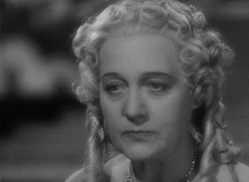 Movie still from “The Scarlet Empress” (1934), directed by Josef von Sternberg – An older woman with long blonde hair wearing a necklace; Close Up shot, High angle