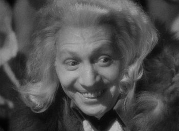 Movie still from “The Scarlet Empress” (1934), directed by Josef von Sternberg – An older woman with blonde ringlet hair smiling for the camera; Close Up shot, High angle