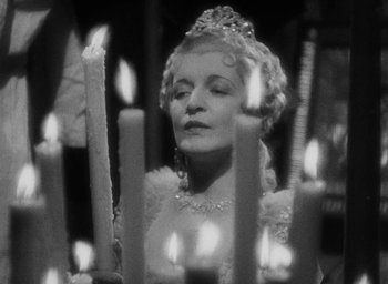 Movie still from “The Scarlet Empress” (1934), directed by Josef von Sternberg – A black and white photo of a woman with candles; Close Up shot, Low angle