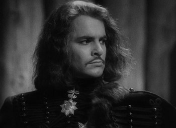 Movie still from “The Scarlet Empress” (1934), directed by Josef von Sternberg – A black and white photo of a man with long hair; Close Up shot, Over the shoulder angle